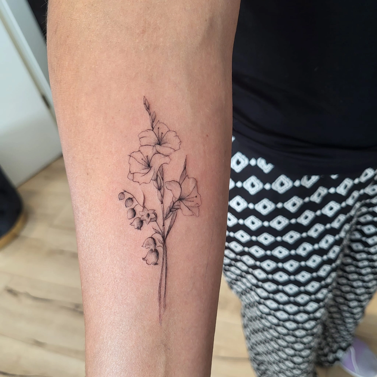 A Fleur de Peau - Professionelles Tattoo Studio - Tätowierung am Arm einer Person