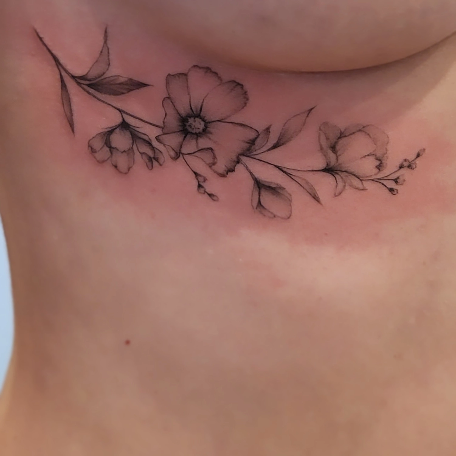 A Fleur de Peau - Professionelles Tattoo Studio - Tätowierung am Hals einer Person
