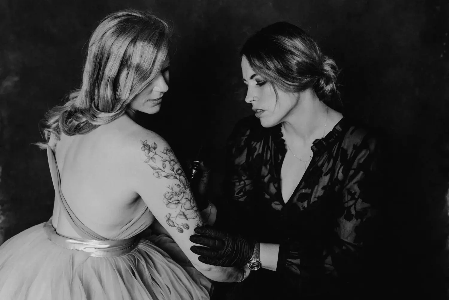 A Fleur de Peau - Professionellen Tattoo Studio - Eine Frau tätowiert den Arm einer anderen Frau