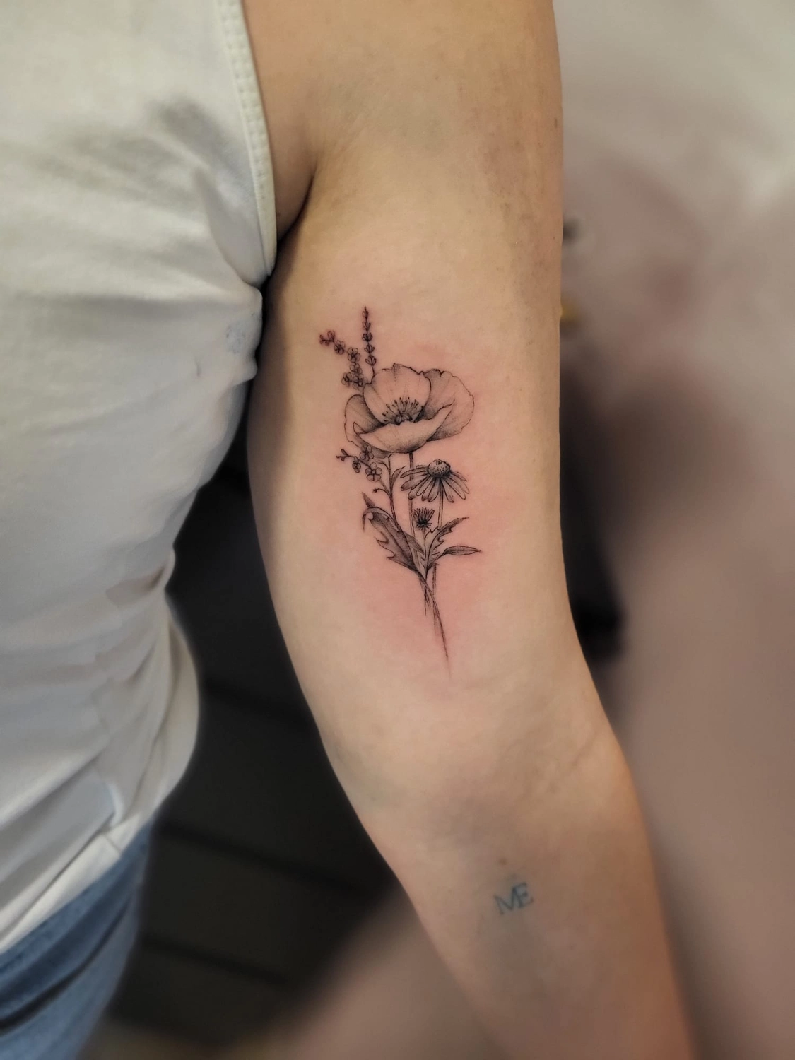 A Fleur de Peau - Professionelles Tattoo Studio - Tätowierung am Arm einer Person